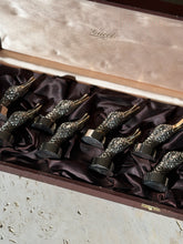 Low angle view of the duck head place card holders in the box, sunlight catching the feather texture below the Gucci Italy lid lining