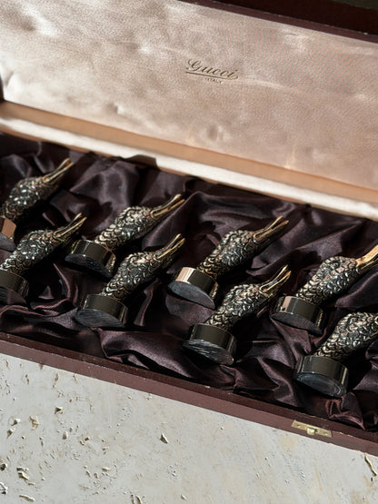 Low angle view of the duck head place card holders in the box, sunlight catching the feather texture below the Gucci Italy lid lining