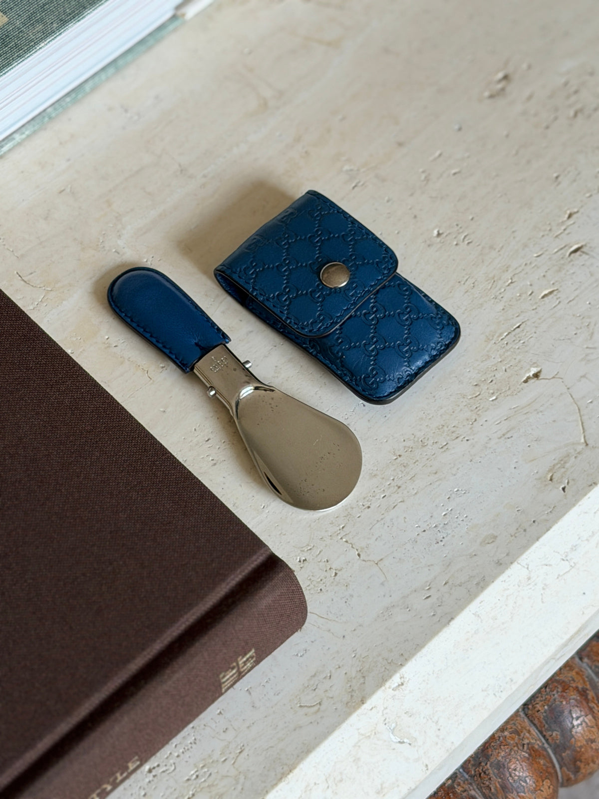 Close-up of the side profile of the Gucci logo stamped on the blue leather shoehorn