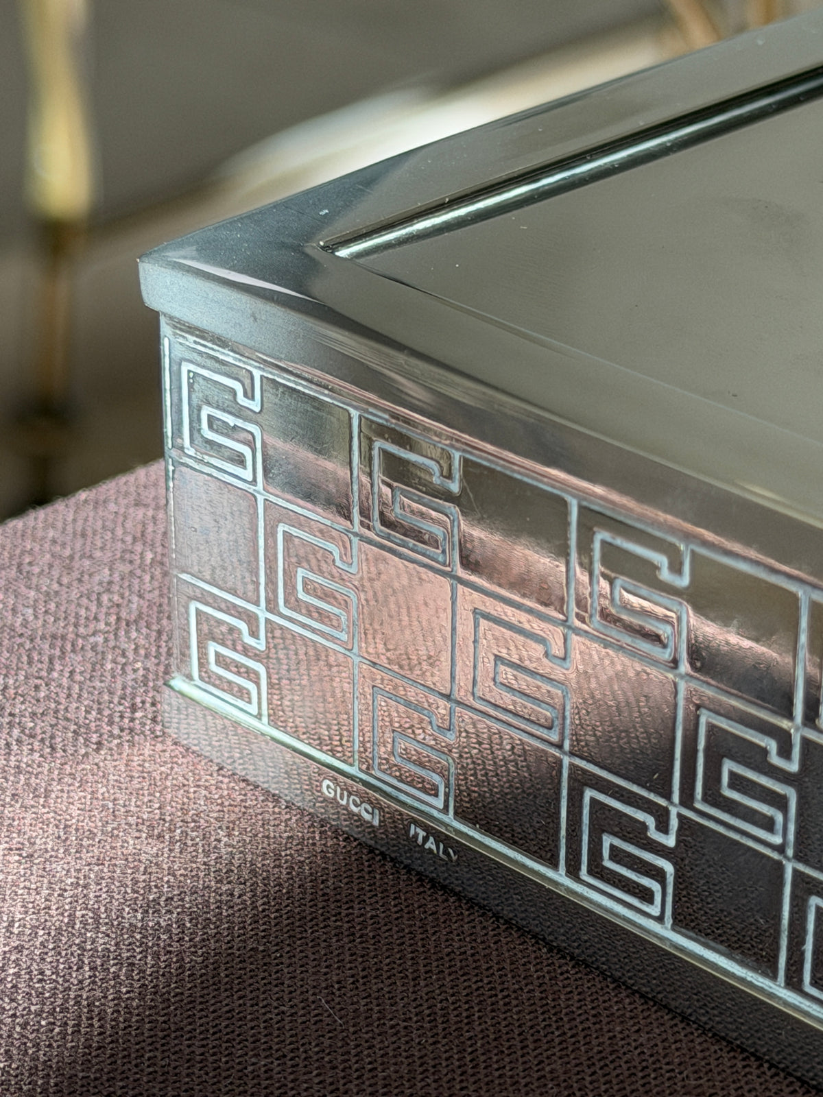 Close up of the corner of the Gucci vide poche, showing the engraved G pattern and the stamped GUCCI ITALY mark