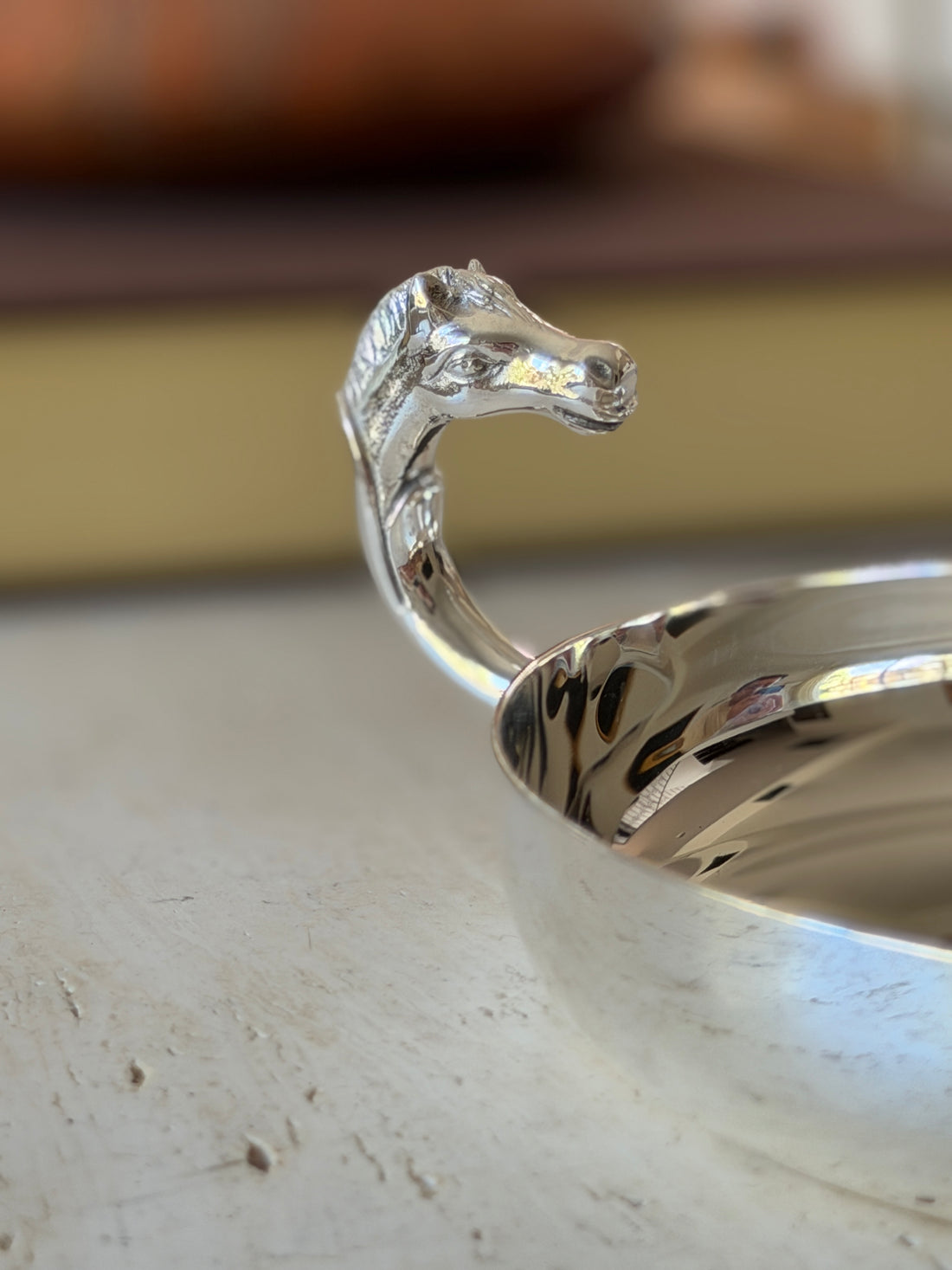 Close-up of the sculpted horse head handle on the Hermes silver catchall