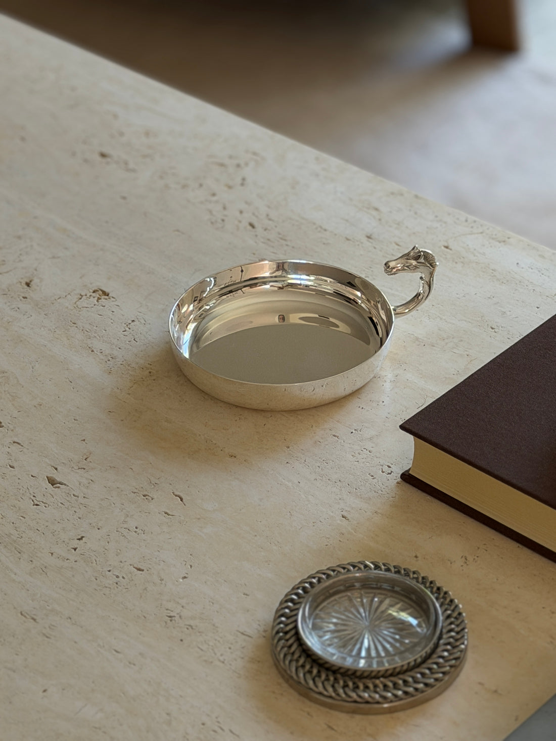 Angled view of the Hermes horse head catchall on a marble surface
