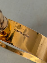 Detail of the HERMES PARIS stamp and hallmark on the inside of the gilt lens frame, beside the handle collar