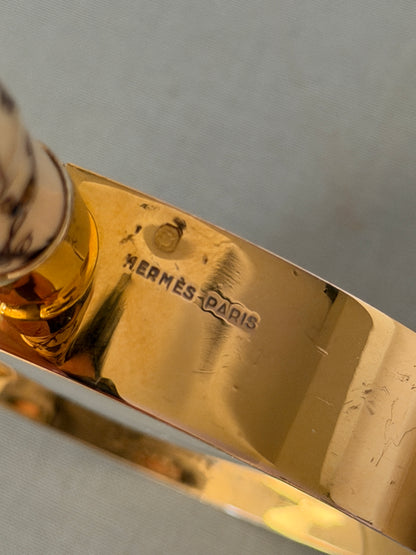 Detail of the HERMES PARIS stamp and hallmark on the inside of the gilt lens frame, beside the handle collar