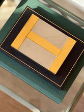 Direct top-down view of Hermes silver-plated box lid featuring prominent brass H motif from Collectors Gene