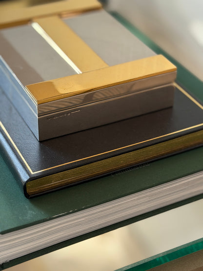 Side perspective view showing brass H detailing and silver plate finish on Hermes box at Collectors Gene