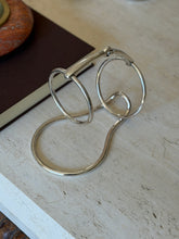 Hermes silver plated wine caddy formed from two large horse bit rings joined by a jointed snaffle bar, rising from a looped wire base