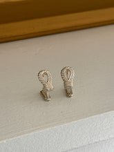 Hermes rope motif cufflinks side by side, each a teardrop loop of twisted rope bound by a ribbed silver wrapping