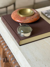 Another angle of the magnifier on the same book, showing the curved spur detail standing in for a handle