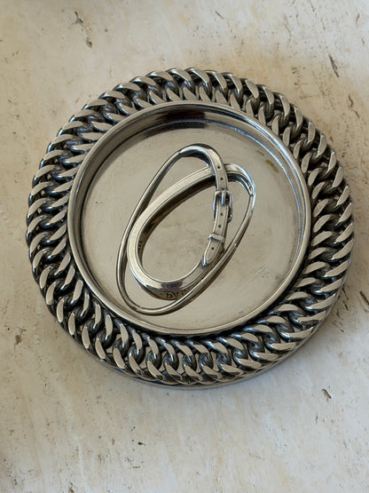 Hermes belt buckle money clip in a round silver dish edged with heavy curb chain, the PARIS stamp visible on the strap