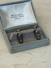 Front view of the original Hermes box holding both anchor chain cufflinks upright on the cushion
