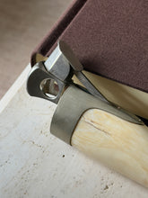 Close detail of the Hermes cigar cutter mechanism, the HERMES PARIS stamp on the steel lever beside the round cutting hole