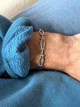 Straight on wrist view of the sterling gated bracelet, alternating open wave links and flat bar sections