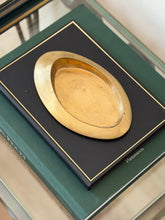 Angled perspective view of 1960s Italian bronze sculptural catchall displayed on dark green book from Collectors Gene