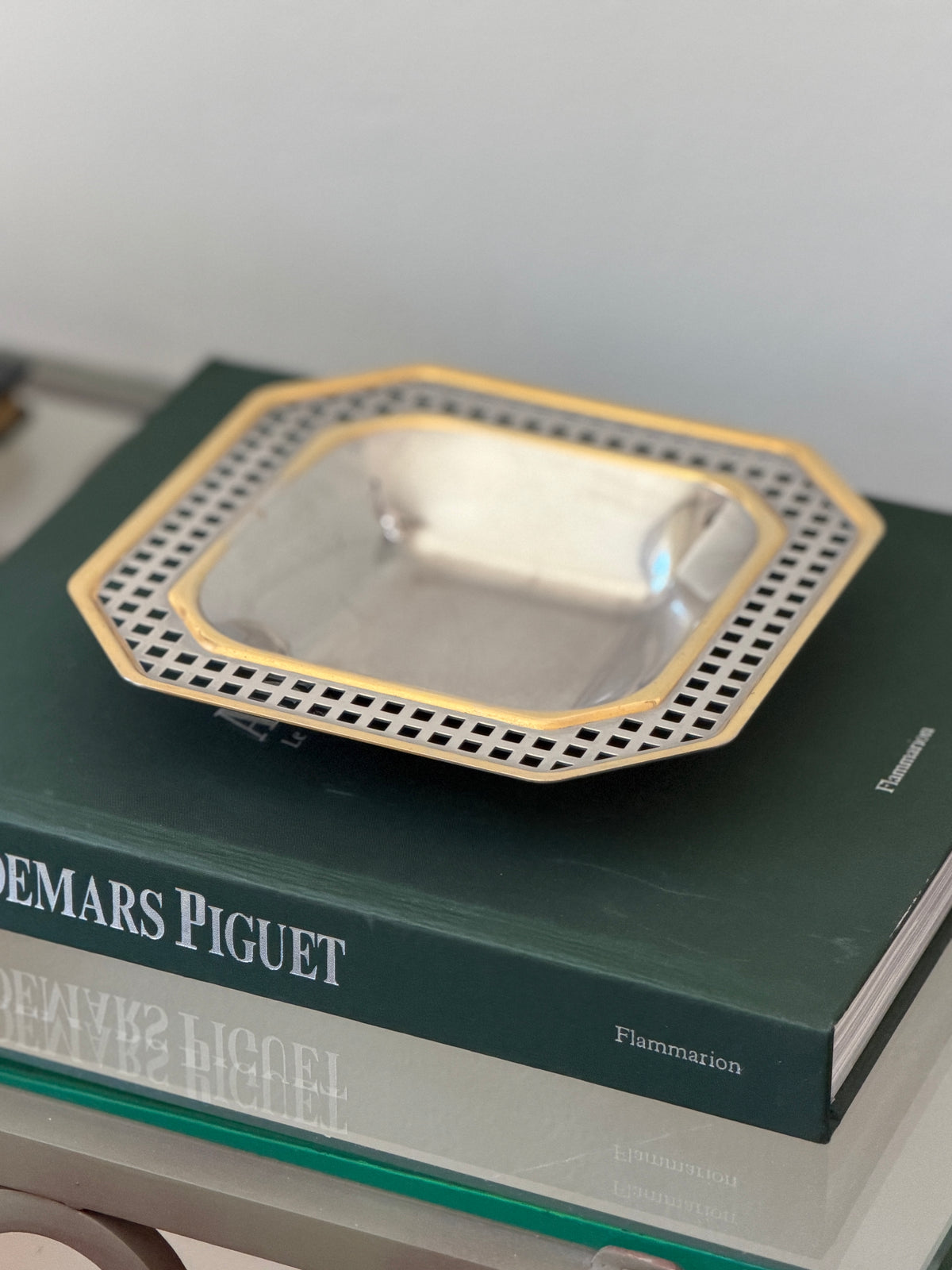 Side profile view of square-recessed octagonal mixed-metal tray displayed on books at Collectors Gene