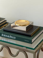 High angle view of square silver and gold-tone two-tone metal vide poche styled on books available at Collectors Gene