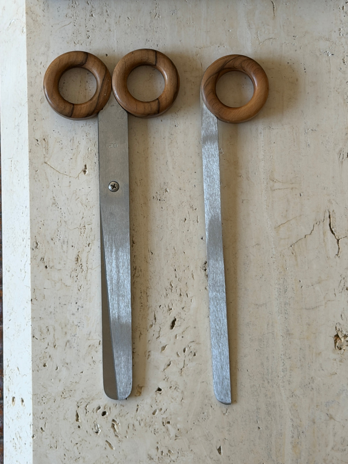 Italian scissors and letter opener laid out together, their matching round wood handles and long brushed steel blades shown in full length
