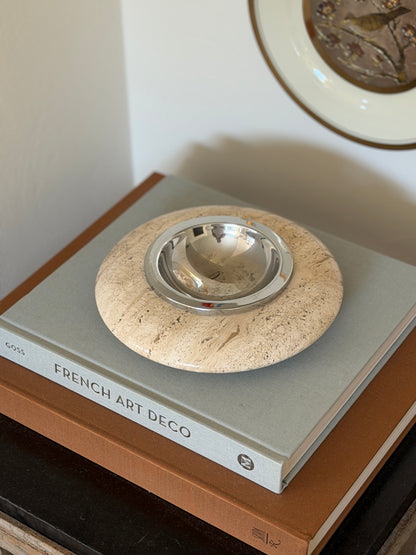 High angle perspective view of round ivory travertine catchall tray displayed on an interior coffee table