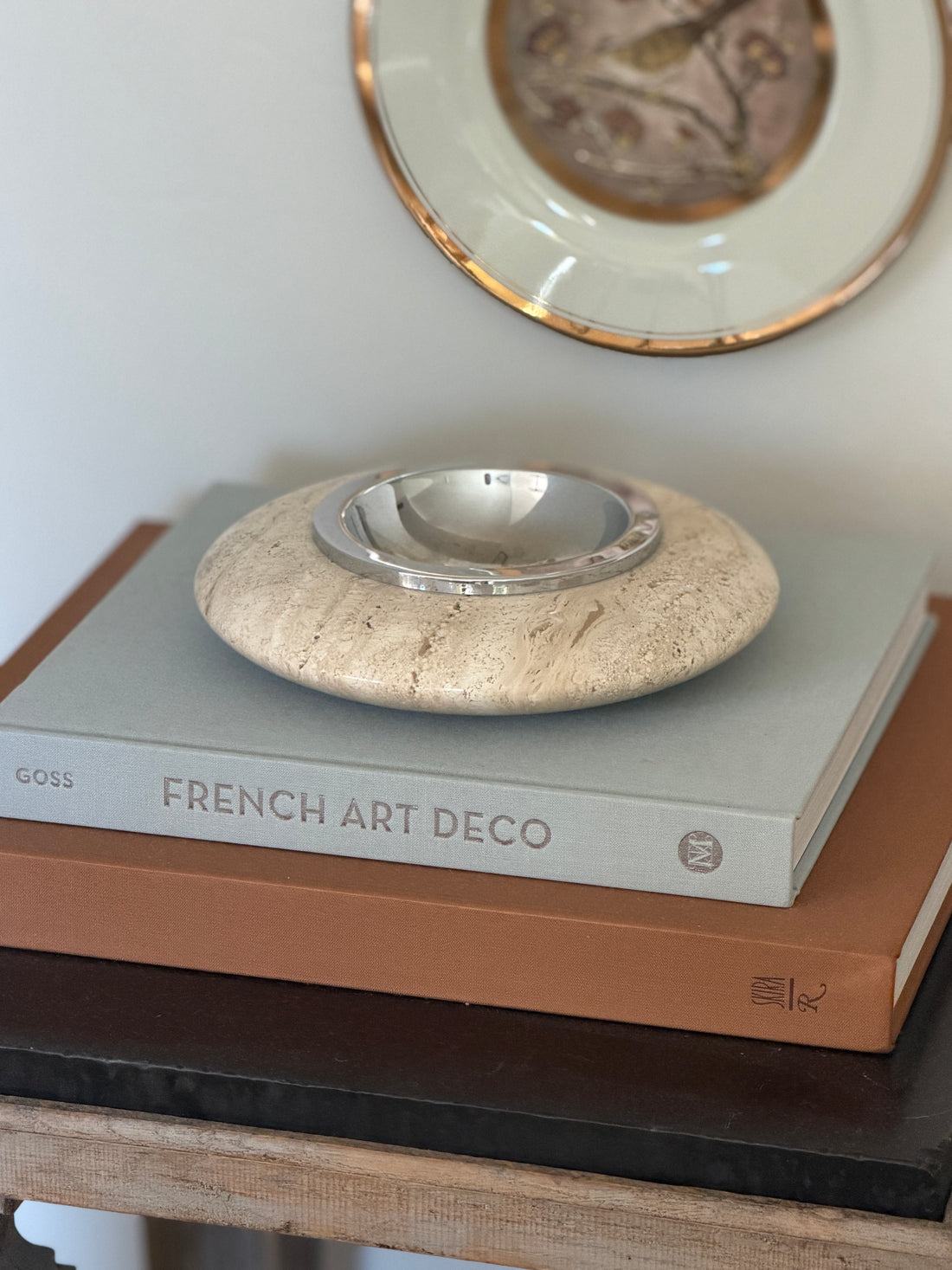 Low angle view of large round cream travertine stone catchall dish with chrome metal insert by Collectors Gene