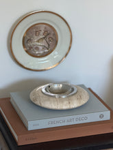 Eye-level view of Italian mid-century travertine vide poche showing porous stone texture and polished metal liner