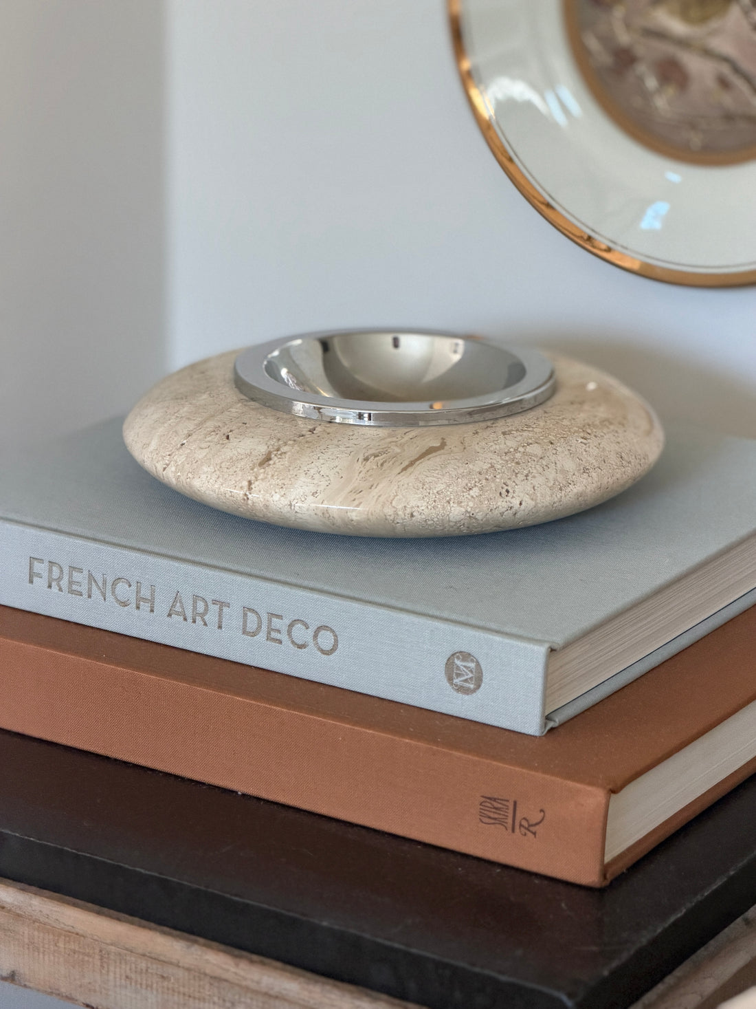 Collectors Gene Italian mid-century cream travertine vide poche tray with polished silver metal bowl center on books