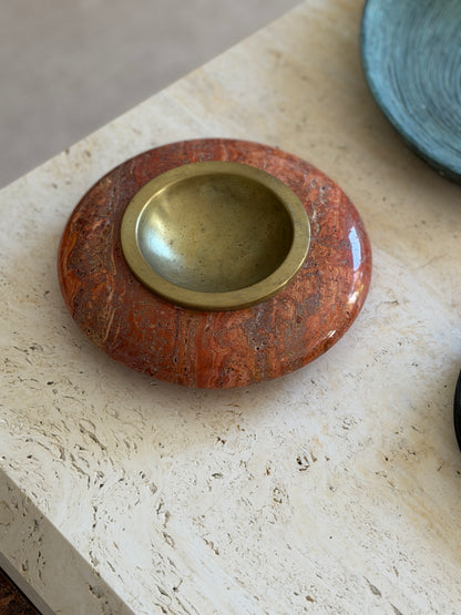 Collectors Gene close-up top view of aged brass bowl insert set in red Rosso travertine stone catchall