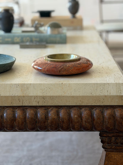 Eye-level side profile view of round Italian Rosso travertine and brass catchall dish by Collectors Gene