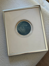 John P. Morgan Nightbird mezzotint in a round cream mat and brushed silver frame, resting on a cream boucle cushion