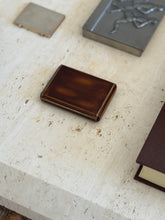 Keller Paris Art Deco box with a mottled brown lacquer lid and silver edged corners, on travertine beside a pewter box and engine turned case