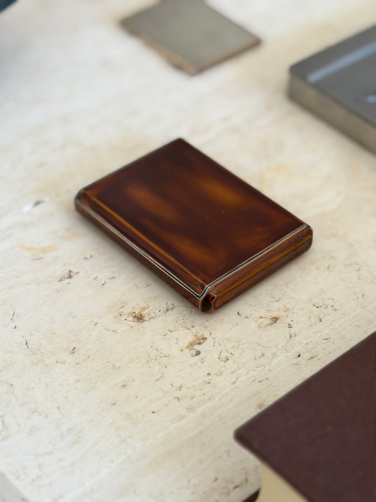 Angled view of the Keller lacquered box, the deep amber and chestnut tones glowing across the domed lid and canted corners