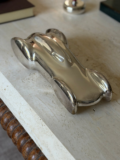 High angle view of the Ralph Lauren race car showing the oval cockpit opening and flowing fenders, a silver lidded box behind