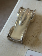 Overhead view of the Clermont race car sculpture, small stamped marks visible on the inner rear fins beside the cockpit