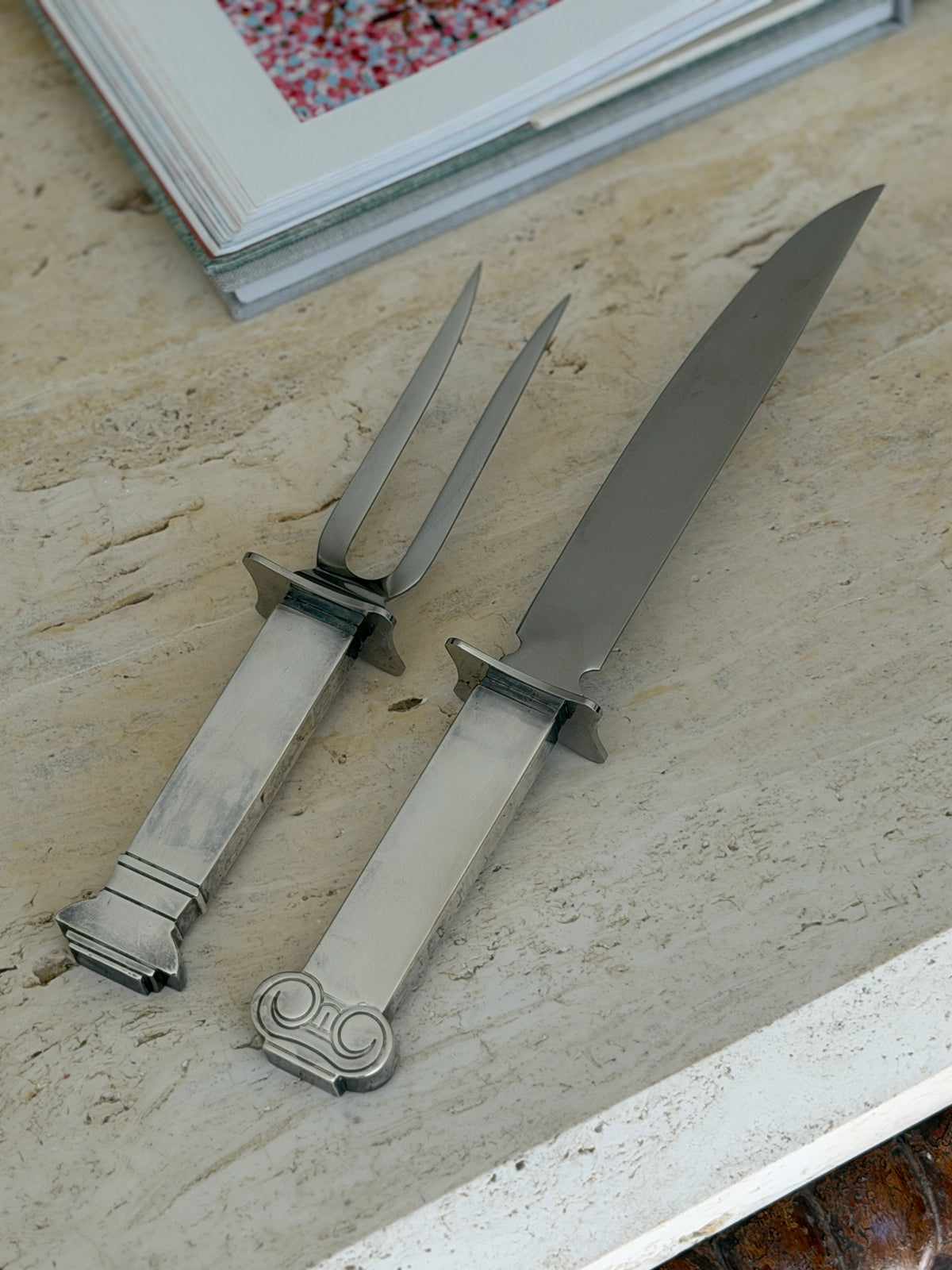 Robert Venturi column carving set for Swid Powell by Reed and Barton, fork and knife with silver column handles on a travertine table