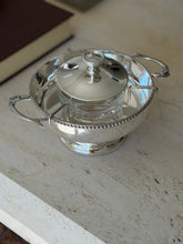 Three quarter view of the silver plate caviar service, showing the wire bracket holding the glass liner and the ring finial lid