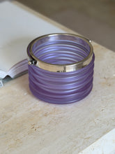 Straight-on view of the bucket showing the full wave-like ribbing along its frosted purple body