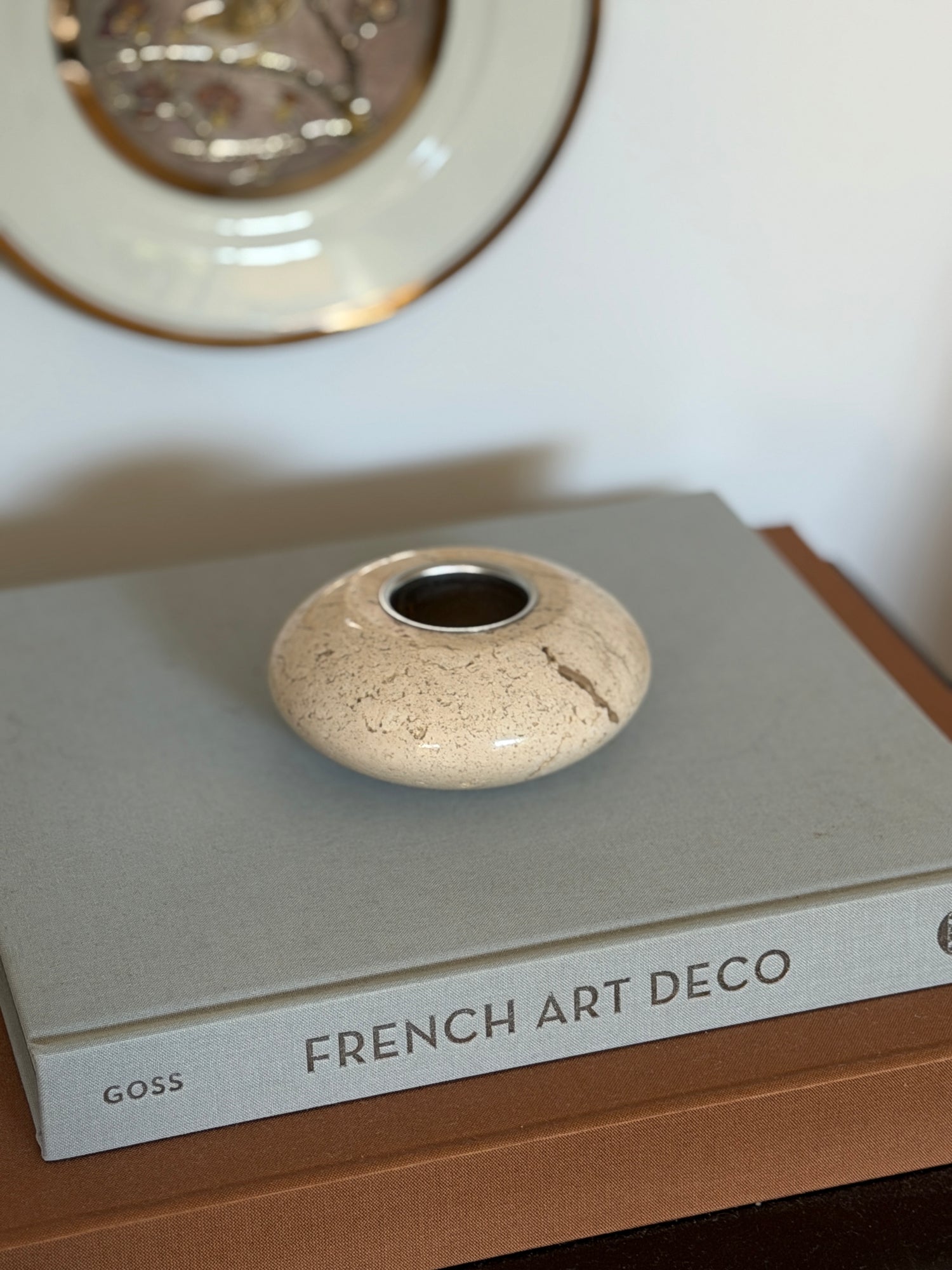 Collectors Gene vintage Italian cream travertine stone catchall tray displayed on a grey coffee table book