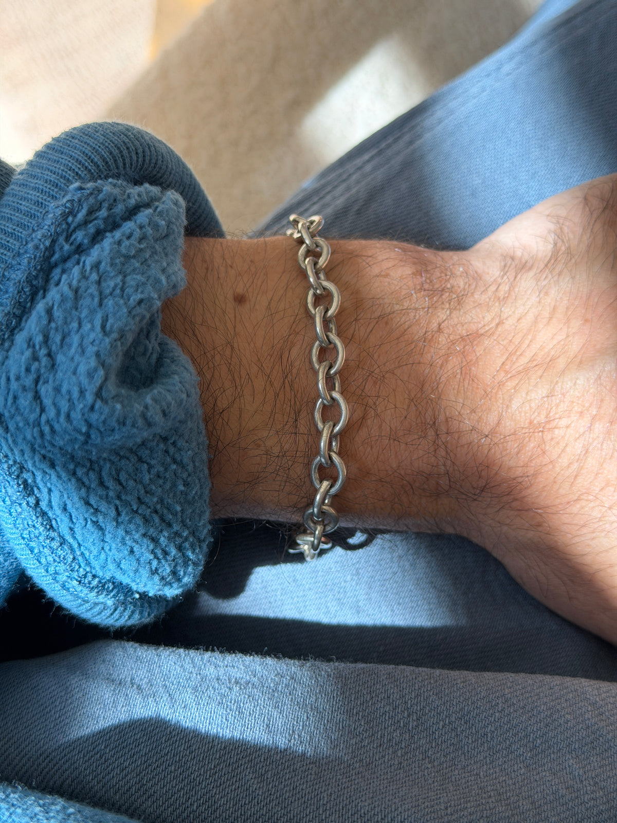 Straight on wrist view of the chunky open link bracelet, a steady run of thick oval links