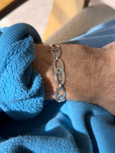 Close wrist view of the infinity link bracelet, the concentric engraved grooves and small barrel connectors between links