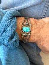 Front view of the sterling cuff on the wrist, the robin egg blue turquoise framed by rope twist wire and small silver dots