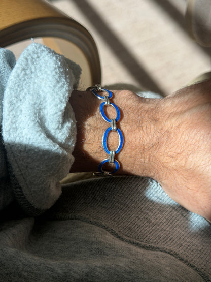 Wrist view of the oval link bracelet in vivid blue enamel, highlighting the grooved double bar links that connect each segment
