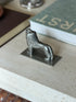 Angled overhead view of the full lion figure on its base plate, next to a green book
