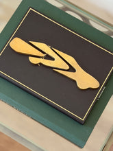 Top-down view of assembled vintage bronze automobile paperweight sculpture on green display book by Collectors Gene