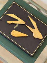 Collectors Gene bronze car paperweight disassembled showing three separate interlocking metal puzzle pieces