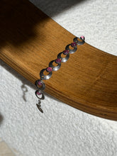 Hermann Siersbol pink cabochon bracelet draped over a bentwood oak chair arm, showing the full run of links and the hook clasp
