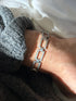 Vintage sterling silver bracelet of open rectangular panel links engraved with diagonal rope lines, joined by smooth barrel hinges, worn on the wrist
