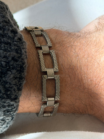 Close view of the sterling panel bracelet, showing the mitered corners, rope engraved sides, and satin finished hinge barrels