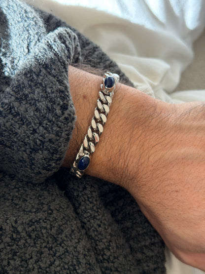 Lapis and silver curb bracelet on the wrist, the deep blue stones flecked with lighter veining between tight polished links