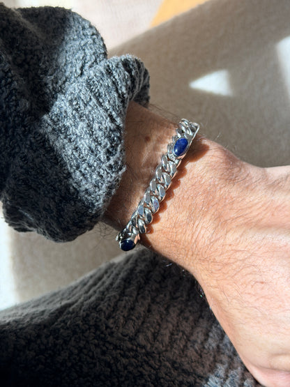 Angled wrist view of the lapis lazuli curb bracelet, a bezel set cabochon framed by the mirror bright chain