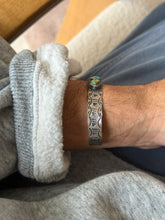 Cuff worn on the wrist, another angle highlighting the stamped pattern along the band