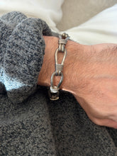 Vintage sterling silver nautical rope link bracelet of elongated teardrop loops bound with coiled wire wraps, worn on the wrist against a gray knit cuff